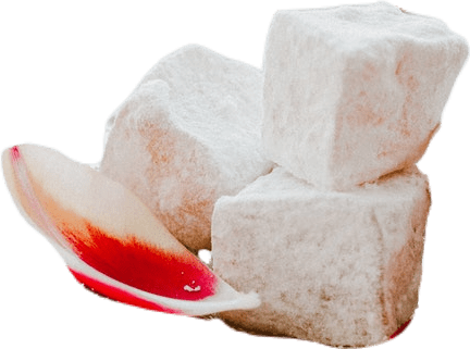 A pile of three pieces of loukhoum, a rose-flavored type of Turkish delight, along with a single red-and-white rose petal.