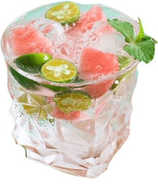 An ornately-shaped crystal glass full of water with mint, watermelon, ice, and limes.