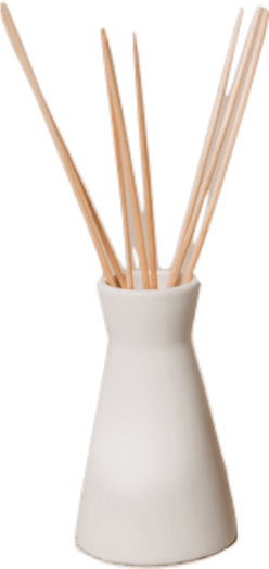 A white vase full of tan-colored wooden sticks of incense.