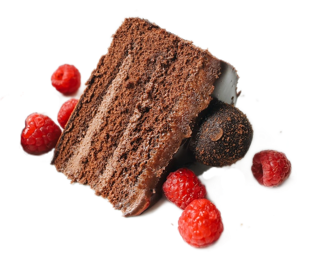 A slice of chocolate cake with chocolate cream topped with a chocolate truffle and sprinkled with raspberries.