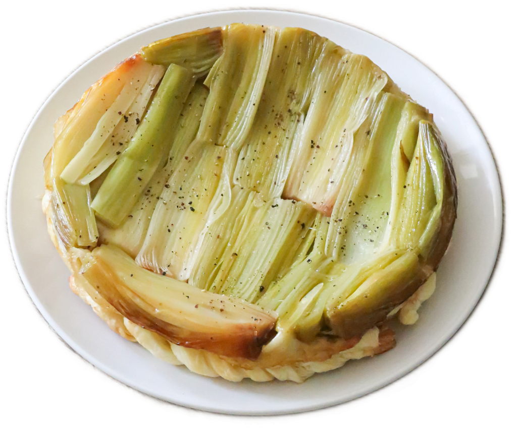 A tart baked pie of light-green rhubarb and spices served on a white ceramic plate.