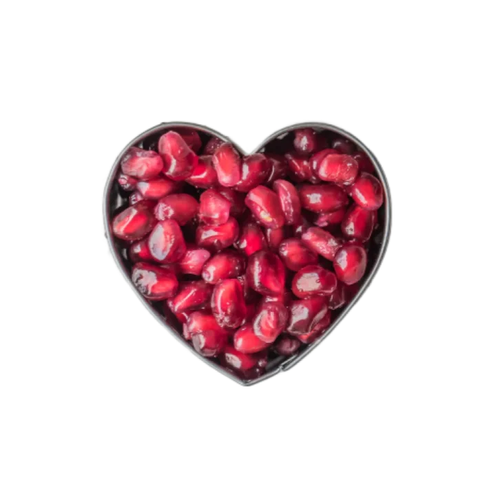 A metal heart-shaped tin filled with bright cerise reddish-pink pomegranate arils.