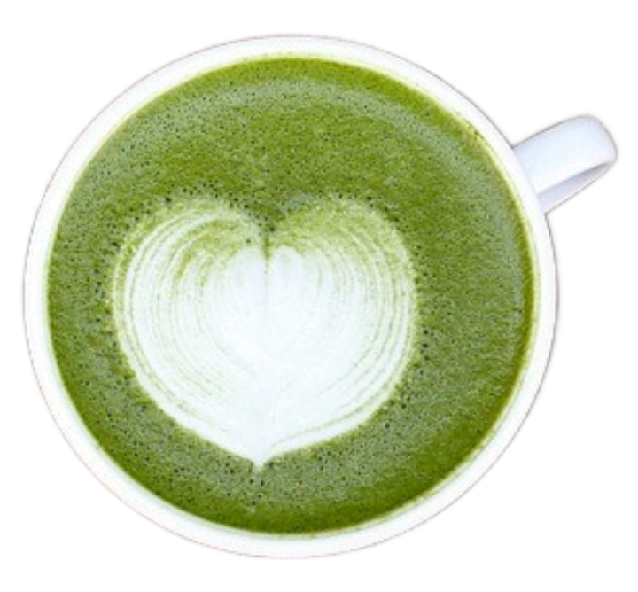 White ceramic porcelain cup filled with foamy, frothy matcha green tea latte with a white creamy latte art heart.