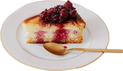 A slice of white cheesecake with berries on top sitting on a white gold-rimmed plate with a gold spoon.