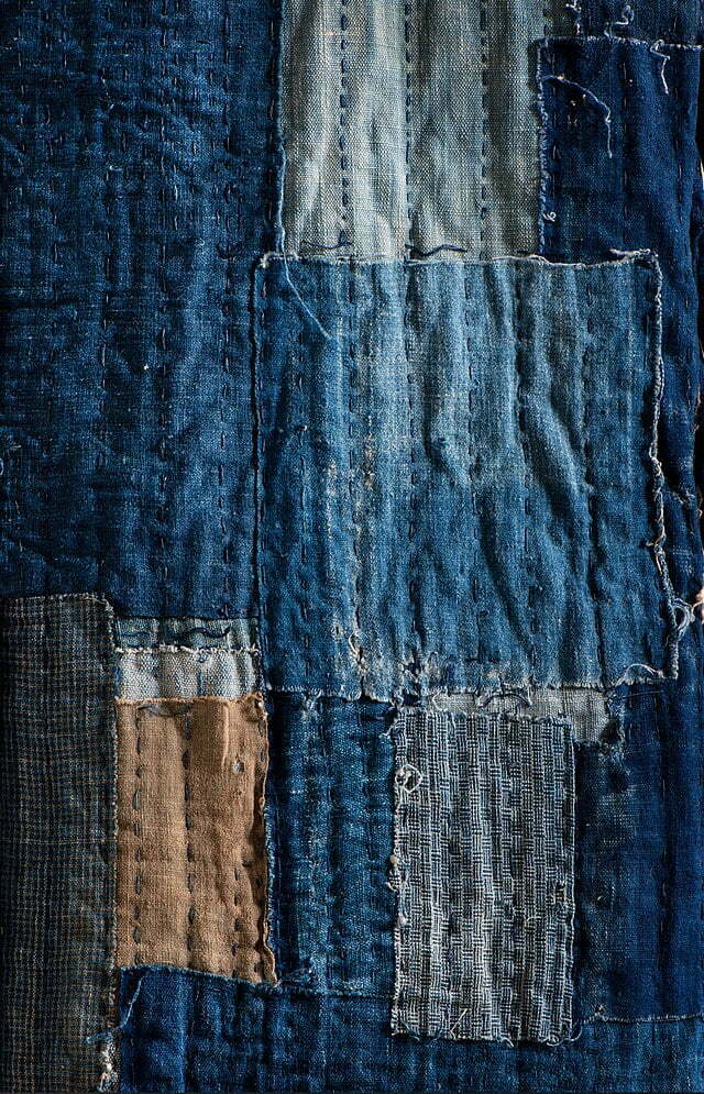 A quilted piece of cloth mended in the Japanese boro style, reinforced with sashiko embroidery.