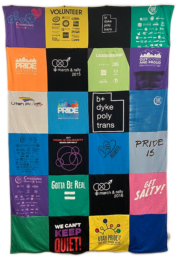 A hanging colorful quilt made out of tee shirts themed around Utah Pride events.