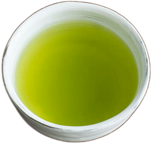 A white, slightly uneven round cup in the Japanese wabi-sabi style filled with bright green sencha tea.