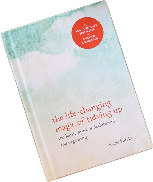 Book cover of The Life-Changing Magic of Tidying Up by Marie Kondo, printed with pale blue and pink sky.