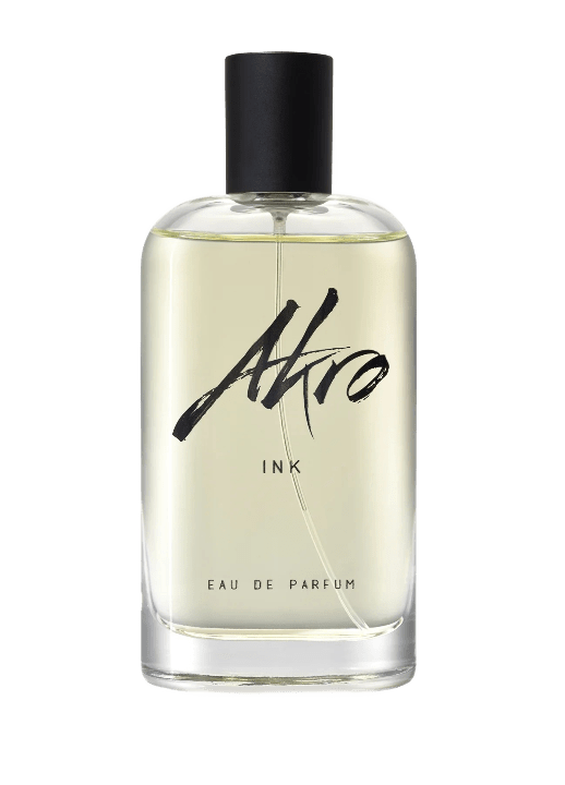 A tall clear glass bottle filled with pale gray liquid with a black cap and label reading Akro in a messy punk scrawl.